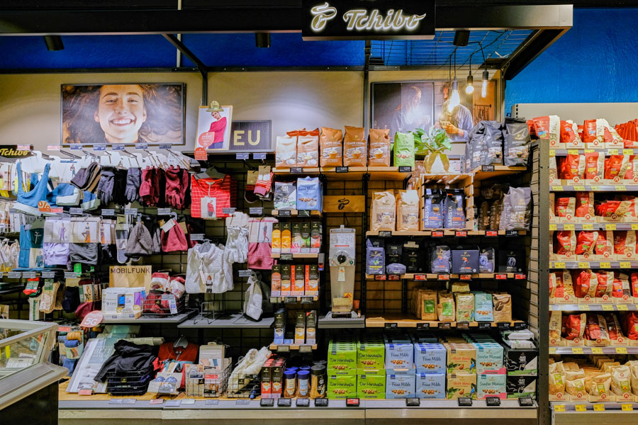 Tchibo-Ecke im Supermarkt mit Kaffee, Zubehör und Aktionswarenregalen.